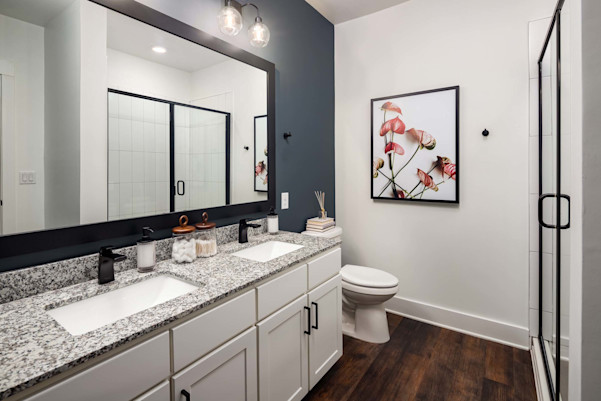 Bathroom with double sink vanity and glass-enclosed shower at Camden West Nashville apartments in Nashville, TN