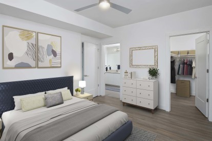 White contemporary bedroom with tray ceiling, walk-in closet, and hardwood-style flooring. 