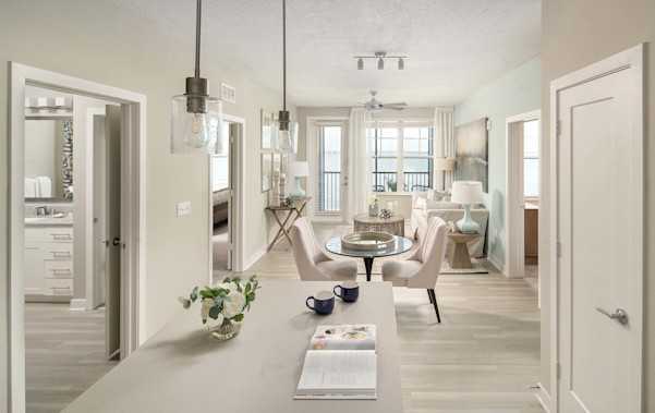 Kitchen with island and pendant lighting leading to dining and living room at Camden Clearwater apartments in Clearwater, FL