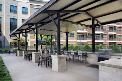 Covered outdoor lounge pavilion with grills, seating and TVs at Camden Victory Park apartments in Dallas, TX