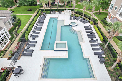 Resort style pool with lounge chairs at Camden Grand Harbor Apartments in Katy, Tx