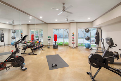Fitness center with studio for stretching, riding the peloton, rowing and kickboxing at Camden Plaza Apartments in Houston, TX 