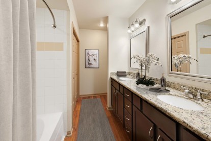Double vanity ensuite bathroom with granite countertops at Camden Greenway Apartments in Houston, TX