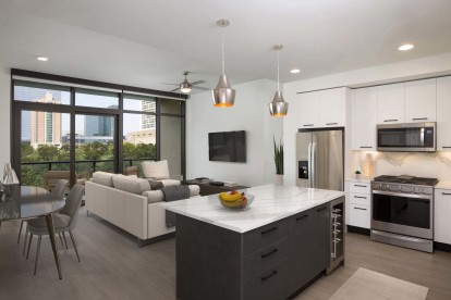 Bright contemporary finishes kitchen with wine and drink fridge and open concept floor plan