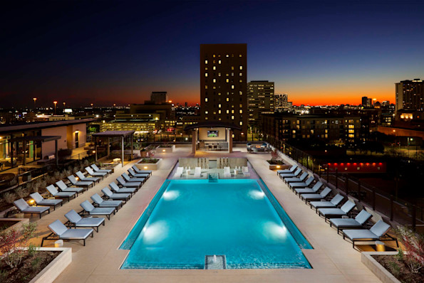 Swimming pool at dusk with fire pit and grills