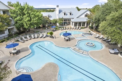 Aerial view of resort-style pool with swim lane and various seating spaces at Camden Stoneleigh apartments in Austin, TX