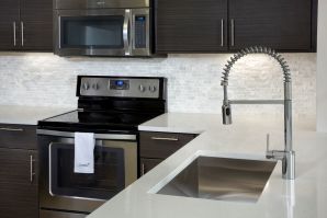 Enjoy your kitchen by using a pull down spray faucet in your single basin stainless steel sink and your ceramic stovetop at Camden Brickell Apartments in Miami, FL.