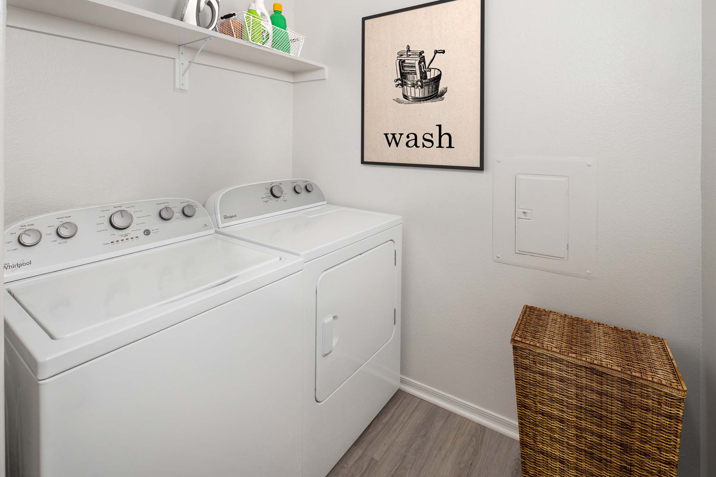 Laundry room with full size washer and dryer and wooden shelf for storage