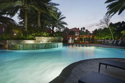 Resort style pool with tanning shelf wifi water features and grills at Camden Holly Springs Apartments in Houston, TX