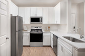 Kitchen with Stainless Steel Appliance, white cabinetry and quartz countertops at Camden Spring Creek Apartments in Spring, TX