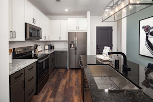 Kitchen with two-tone light and dark cabinets and wood-style flooring at Camden West Nashville apartments in Nashville, TN