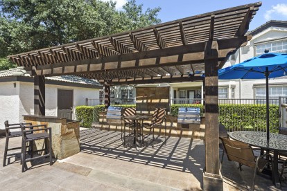 Poolside cabana with grills and seating at Camden Legacy Park apartments in Plano, TX