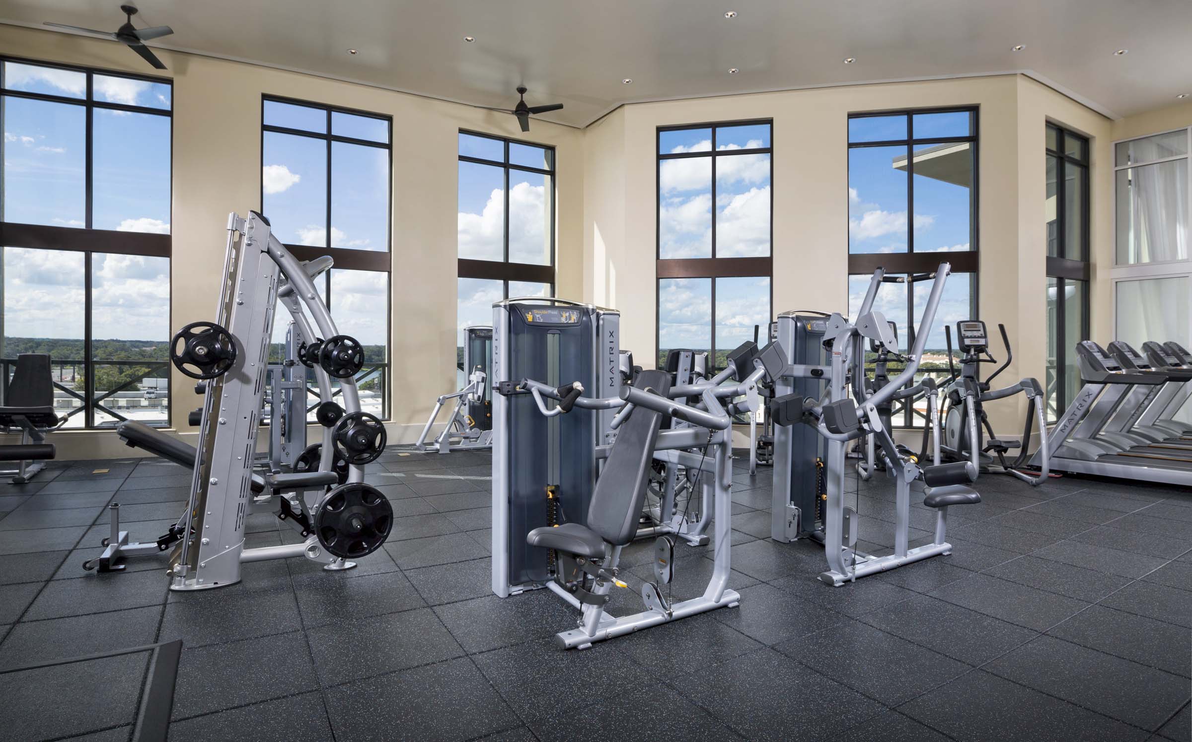 Rooftop fitness center with cardio equipment overlooking lake concord