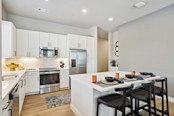 Kitchen with island and white cabinets at Camden Roanoke apartments in Roanoke, TX