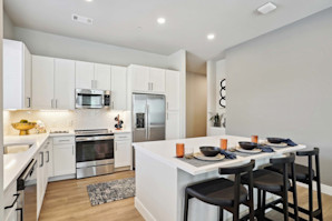 Kitchen with island and white cabinets at Camden Roanoke apartments in Roanoke, TX