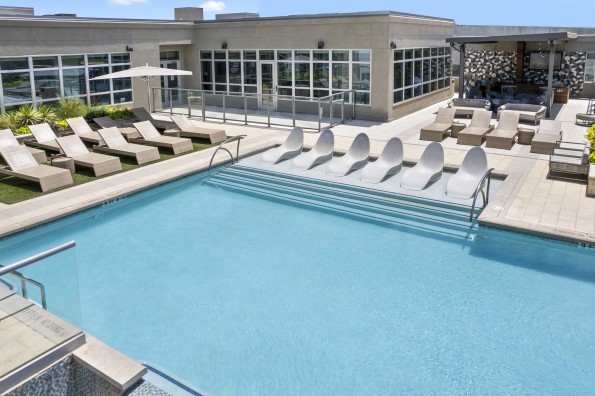 Spacious pool and sundeck with in-water loungers at Camden Rainey Street