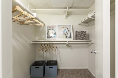Walk in closet with built in shelves and hanger rods