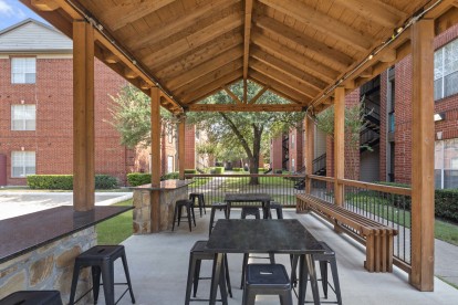 Covered pavilion with seating next to the volleyball court at Camden Addison