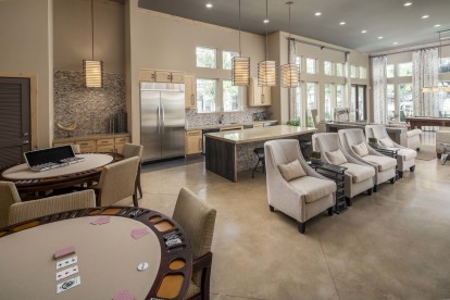 Clubroom with entertaining kitchen, lounge area, and poker tables at Camden La Frontera apartments in Austin, TX