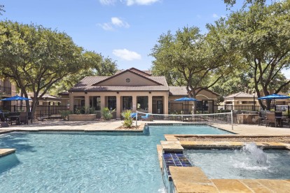 Resort-style pool with volleyball net and fountain at Camden Cimarron apartments in Irving, TX