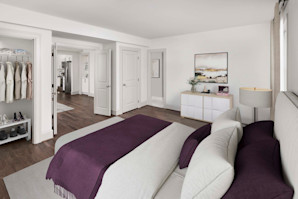 Spacious primary bedroom with French doors and an en-suite bathroom at Camden Roosevelt apartments in Washington, DC.