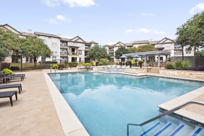 Resort-style pool with lounge seating at Camden Cedar Hills apartments in Austin, TX