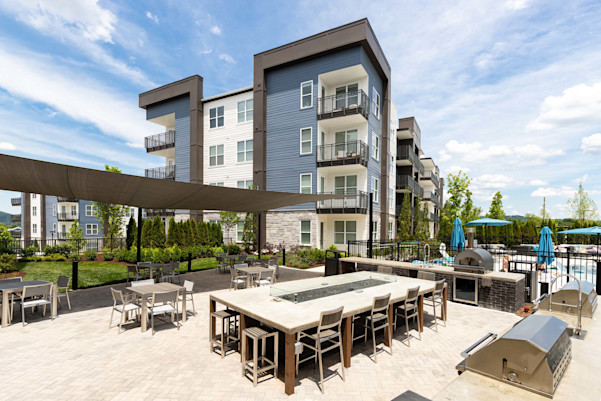 Outdoor kitchen with gas grills, pizza oven, gas fire table, and covered seating at Camden West Nashville apartments in Nashville, TN