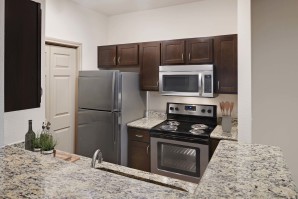 Kitchen with stainless steel appliances and granite countertops at Camden Greenway Apartments in Houston, TX