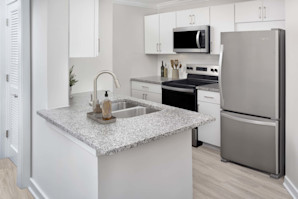 Modern renovated kitchen with white cabinetry and granite countertops at Camden Midtown Atlanta in Atlanta, GA