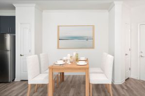 Open kitchen and dining area with wood-inspired flooring.