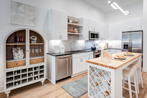 Stunning, Modern White kitchen with butcher block counter top and built-in wine rack.