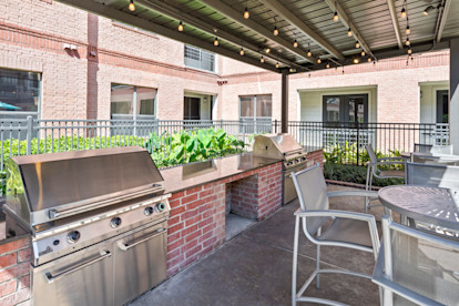 Outdoor grills with dining tables at Camden Travis Street Apartments in Midtown Houston, Tx