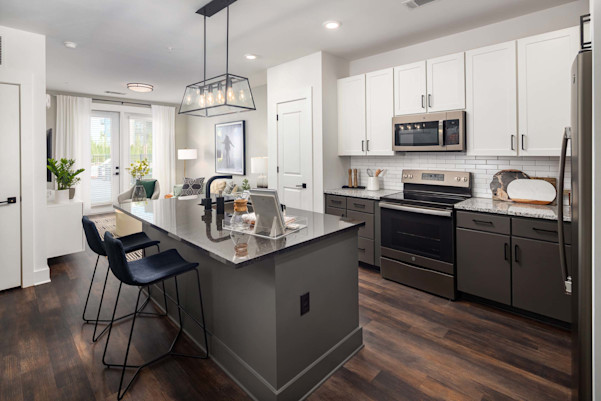 Two-tone kitchen cabinets and island with modern pendant fixture at Camden West Nashville apartments in Nashville, TN