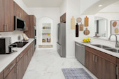Kitchen with quartz countertops, stainless steel appliances, and large pantry in a penthouse apartment home at Camden Post Oak in Houston, TX