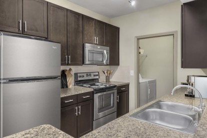 Kitchen with stainless steel appliances next to laundry room with full size washer and dryer