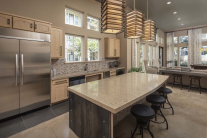 Clubroom entertaining kitchen with full-size appliances and extended island seating at Camden La Frontera apartments in Austin, TX