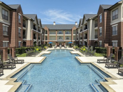 Pool 1 sundeck lined with lounge chairs at Camden Farmers Market apartments in Dallas, TX