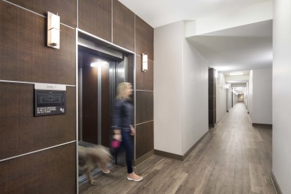 Resident exiting elevator with dog at Camden Henderson