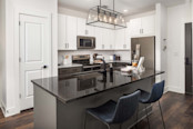 Kitchen with light and dark cabinets and countertops and modern island pendant fixture at Camden West Nashville apartments in Nashville, TN