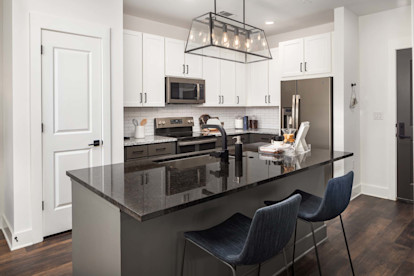 Kitchen with light and dark cabinets and countertops and modern island pendant fixture at Camden West Nashville apartments in Nashville, TN