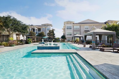 Swimming pool with lounge chairs and water feature at Camden Northpointe in Tomball, TX