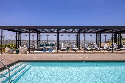 Camden Hillcrest Apartments San Diego CA expansive pool and loungers under a cabana with views of Mission Valley