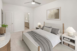 Bedroom with lighted ceiling fan and ensuite bath at Camden Westwood apartments in Morrisville, NC