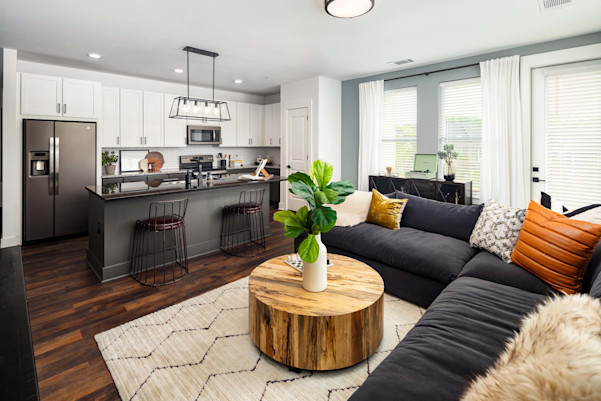 Living room with wood-style flooring and private balcony access at Camden West Nashville apartments in Nashville, TN