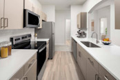 Chef-inspired kitchen with quartz countertop and stainless steel appliances at Camden Westwood apartments in Morrisville, NC