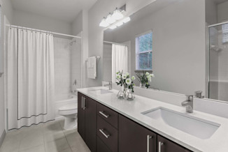 Bathroom with double sinks, cabinet storage, a window with natural light, and a shower/bathtub at Camden Asbury Village in Raleigh, NC. 