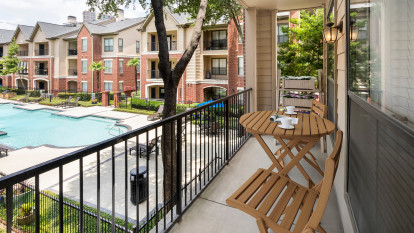 Balcony overlooking pool at Camden Farmers Market Apartments in Dallas, TX