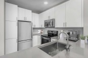 Kitchen with gray quartz countertops and white cabinets