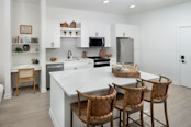 Chef-inspired kitchen with stainless steel appliances and quartz countertops as well as a built-in desk at Camden Blakeney apartments in Charlotte, NC