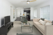 White quartz finishes in kitchen with island overlooking the living room with ceiling fan